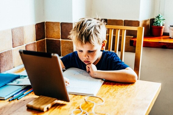 Boy_sitting_on_table_doing_homework__kopie_