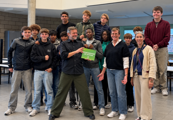 Oxfam overhandigt het WOS-school muurplaatje aan leerlingen en leerkrachten economie van het OLVRode.